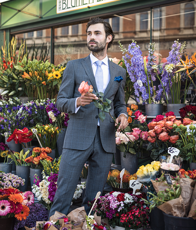 Gentleman im Anzug kauft Blumen in Wien
