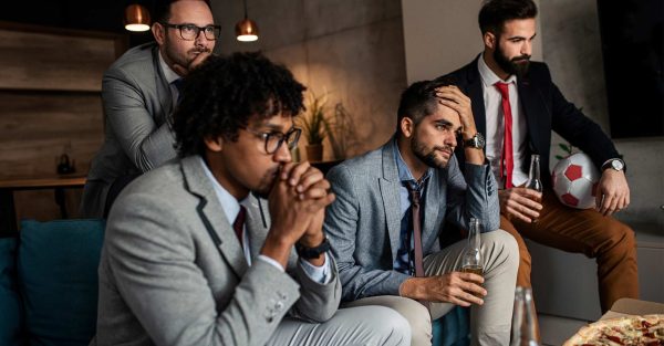 Männer im Anzug schauen Fußball